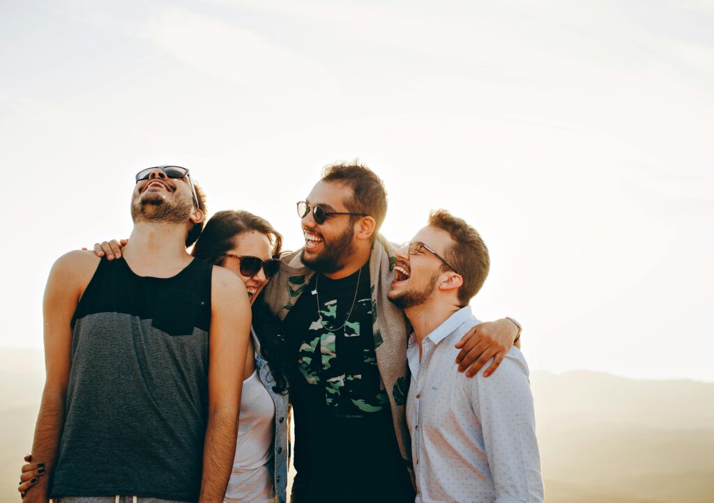 pexels-photo-708440-708440 A group of young adults laughing and enjoying time together outdoors under the sun.